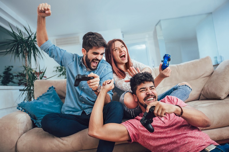 three people on a couch playing video games