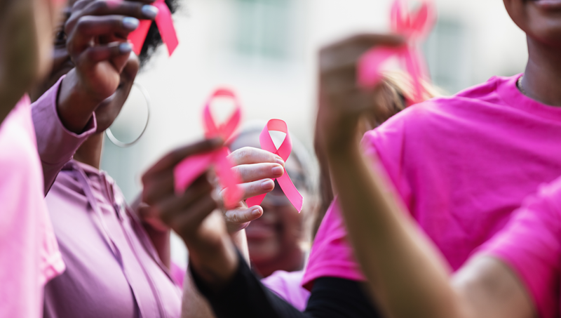 People holding up pink ribbons