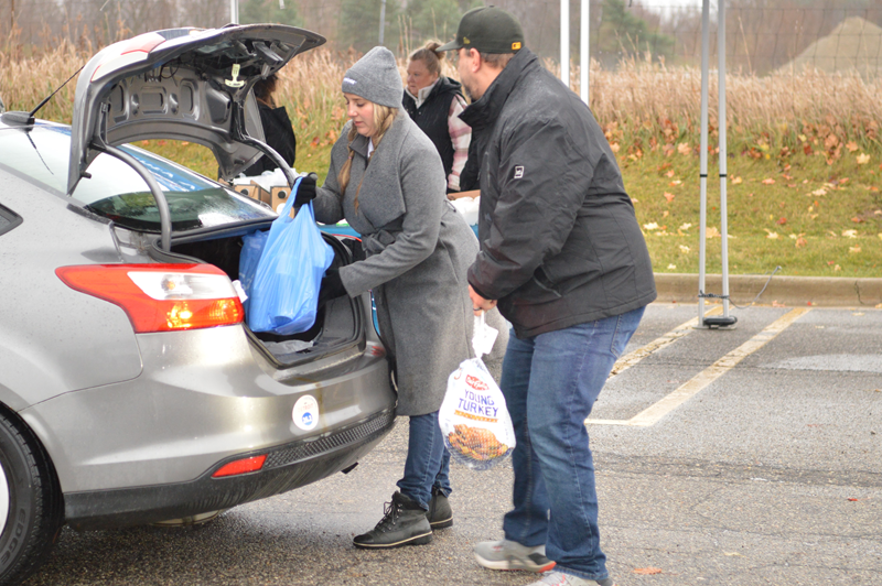 People loading groceries into a car