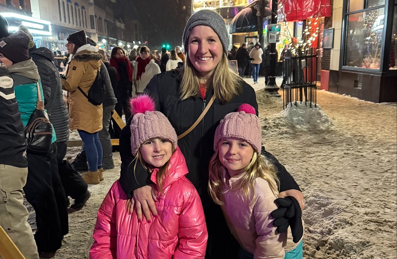 Woman with two girls on a winter street at night