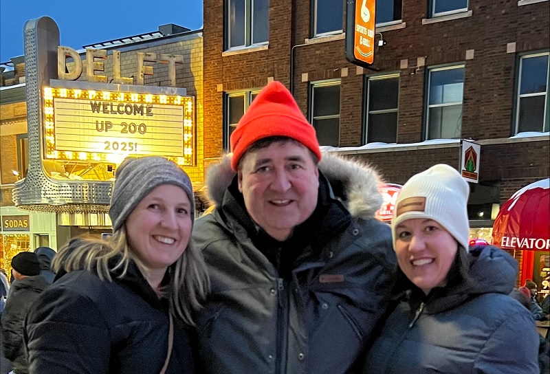 Three people on a winter street at night