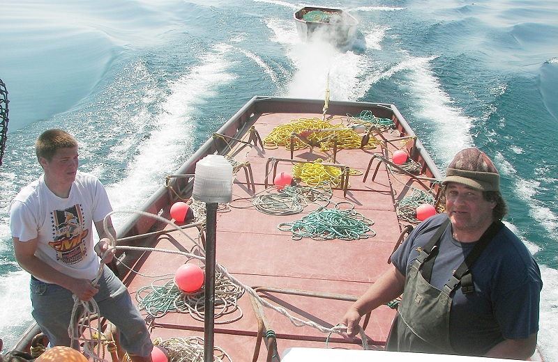 Two men on a boat moving through the water