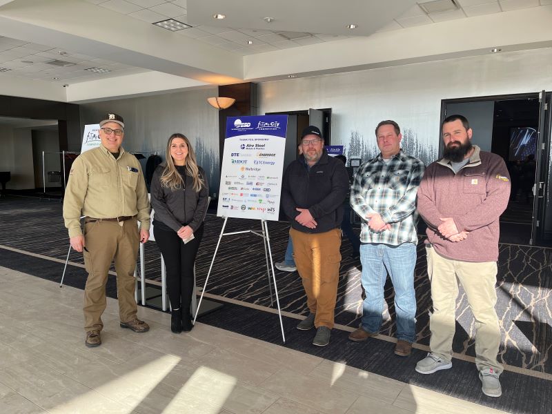 A group of people standing with an event sign