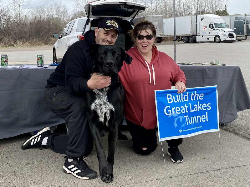 couple poses with their dog