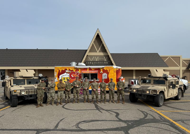 A group of Army National Guard members standing in front of a food truck