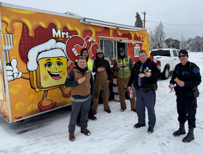 A group of people standing in front of a food truck