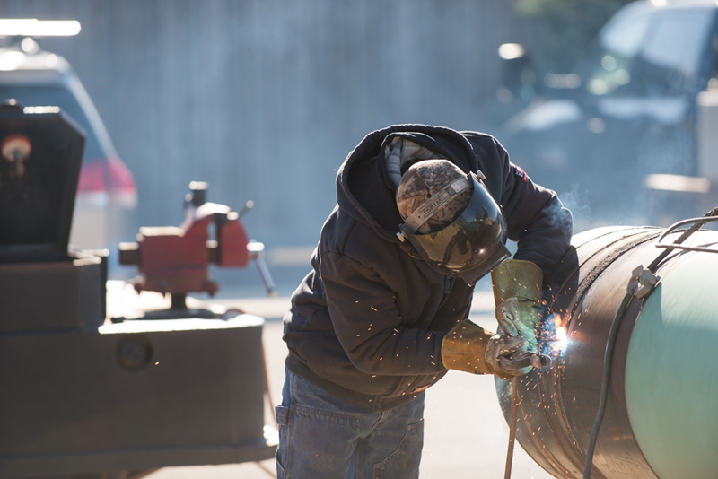 Welder working on pipe