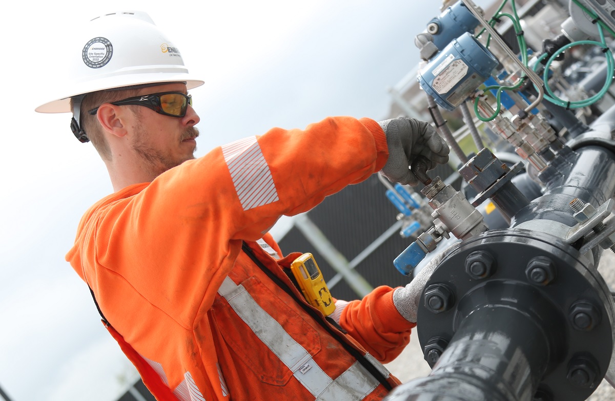 Worker adjusting pipes and valves