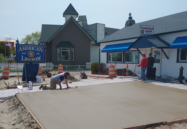 Workers laying a cement patio