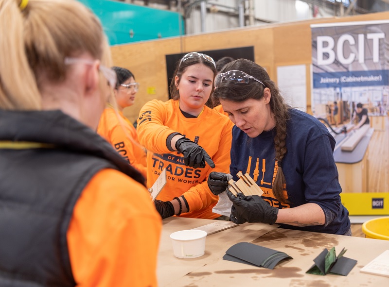 Women in workshop sanding pieces of wood