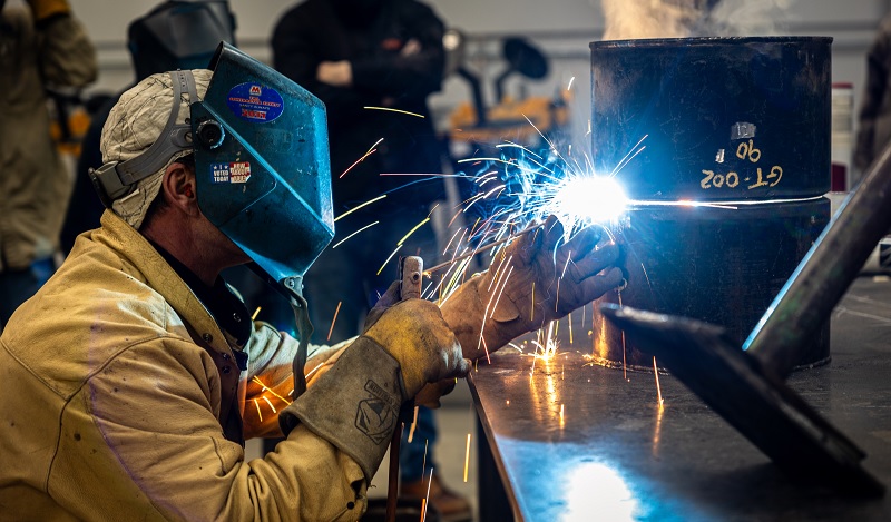 Welder wearing helmet doing stick welding