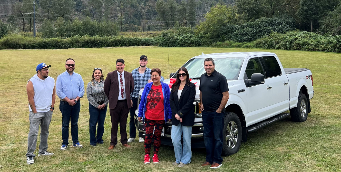 Group of people in front of a white truck